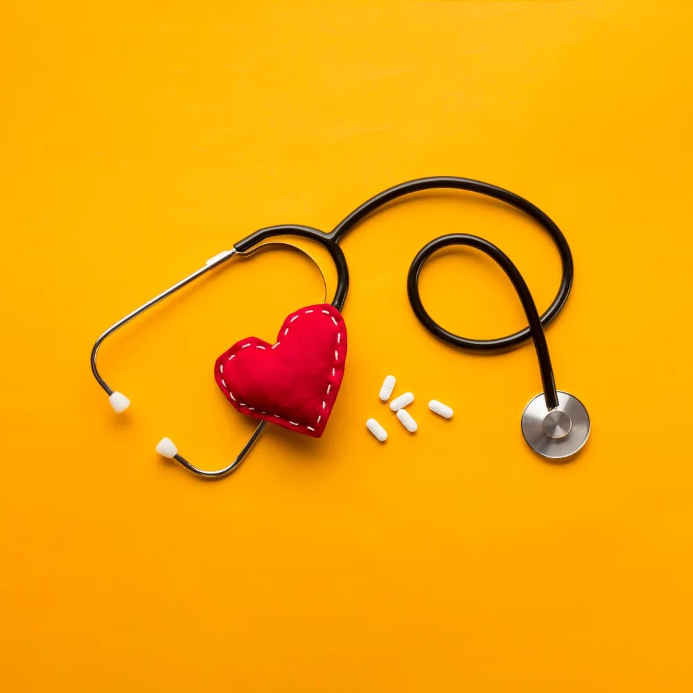 6501d51e7a0eb38089fa539f_high-angle-view-stethoscope-stitched-heart-medicines-yellow-backdrop