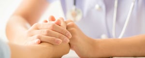 health care practitioner holding clinical trial participant's hand in support. Concept of caring