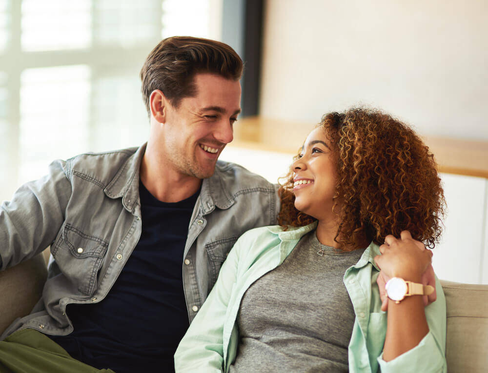 happy-young-couple-looking-into-one-anothers-eyes-home