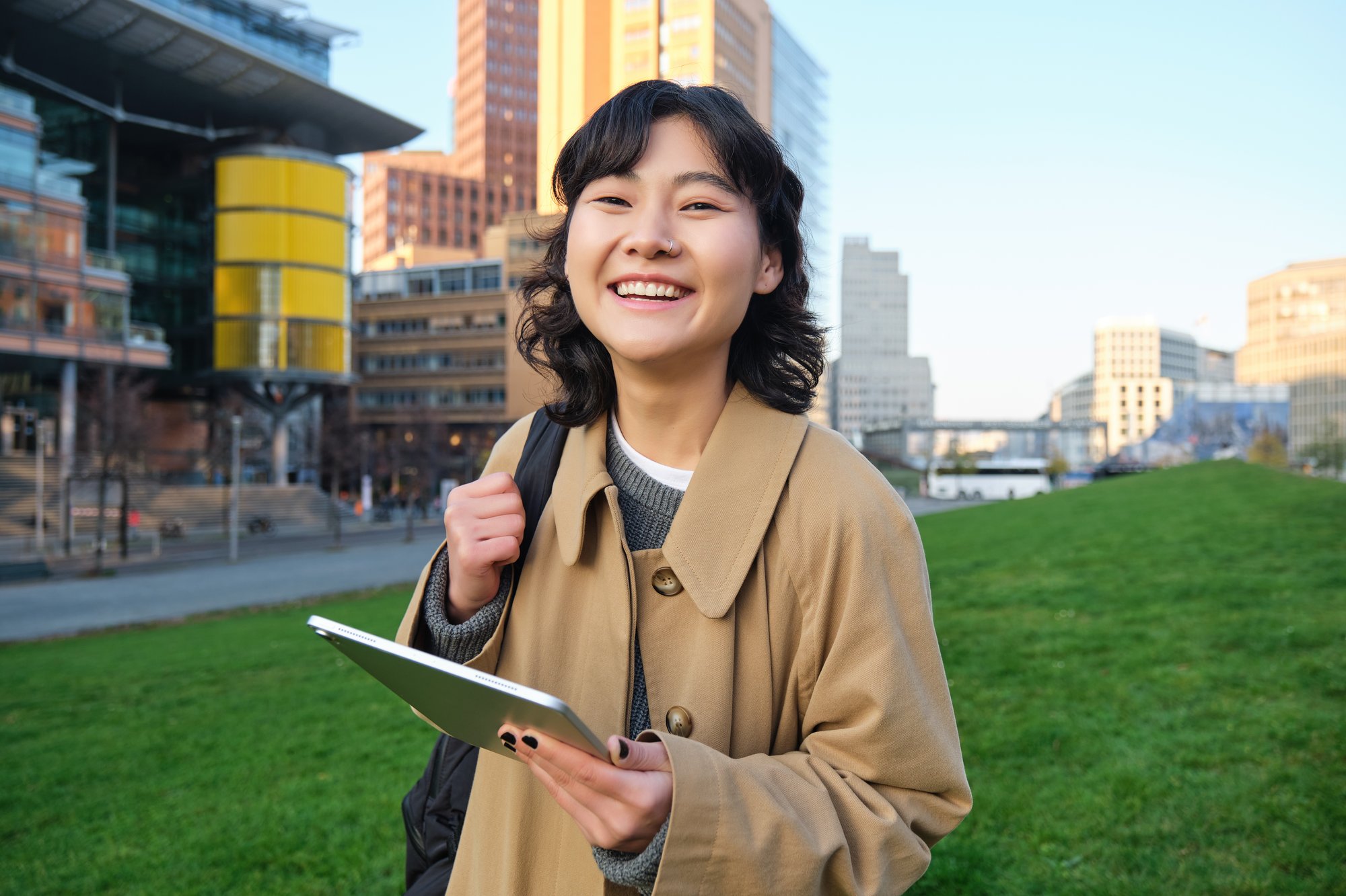 happy-young-brunette-girl-asian-woman-walks-around-city-with-tablet-goes-university-with-her-digi