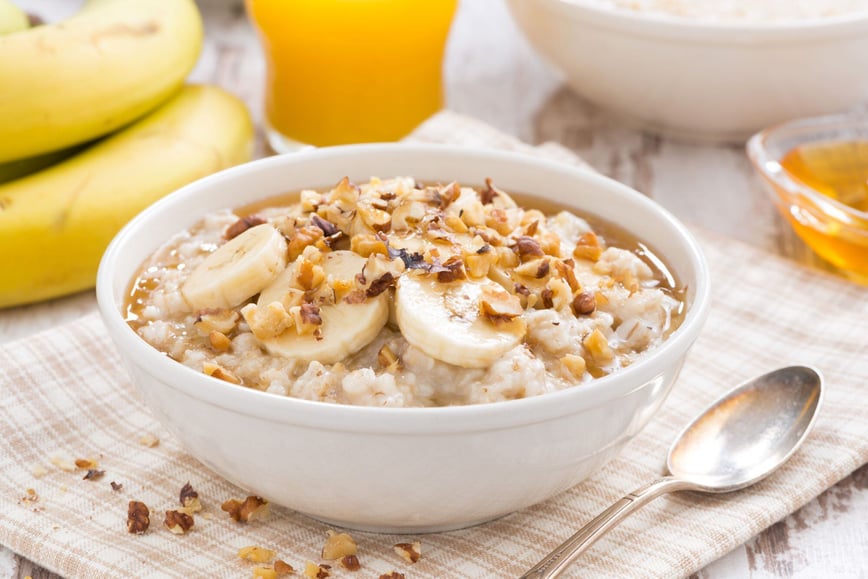 oatmeal with banana, honey and walnuts in bowl for breakfast reduced