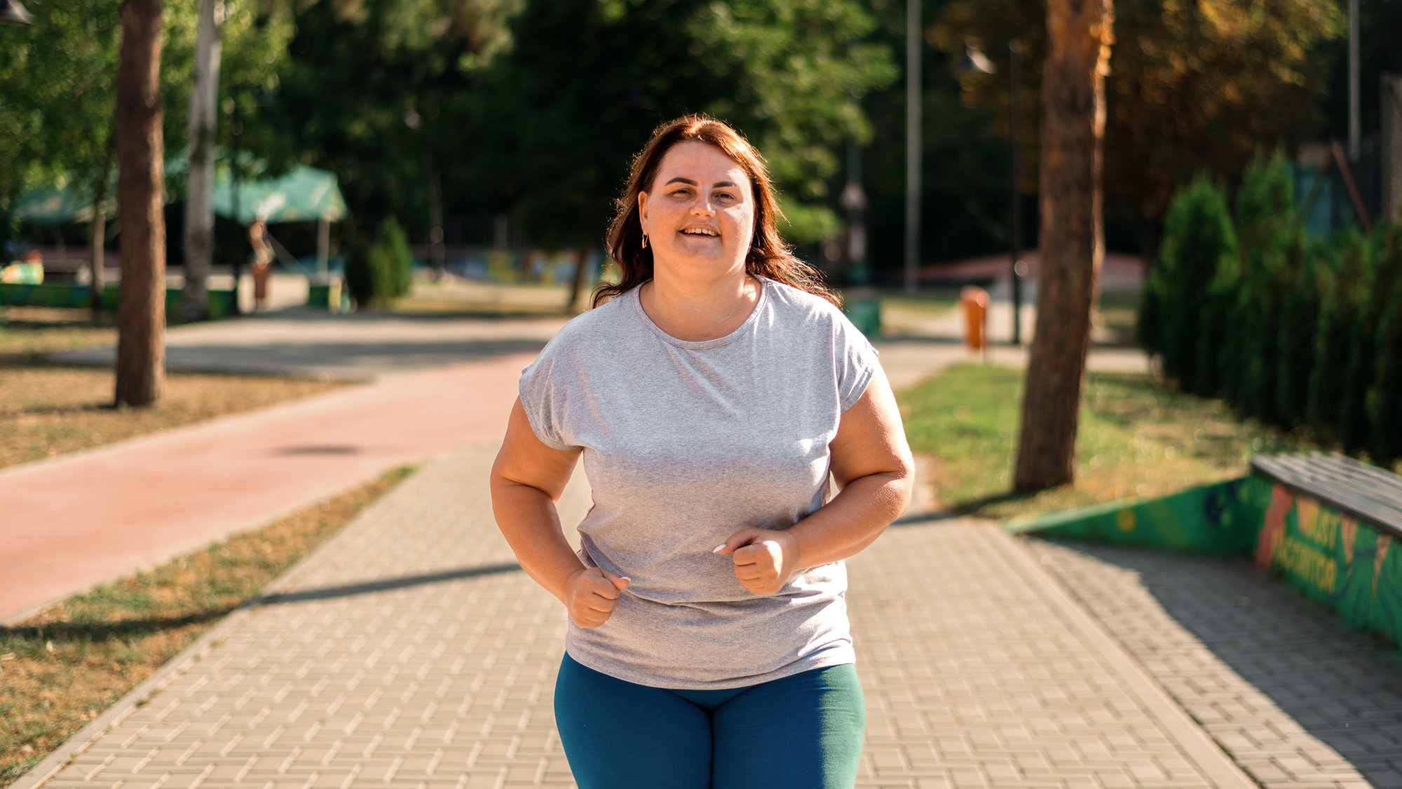 smiling-woman-with-overweight-tracksuit-running-park smiling-woman-with-overweight-tracksuit-running-park
