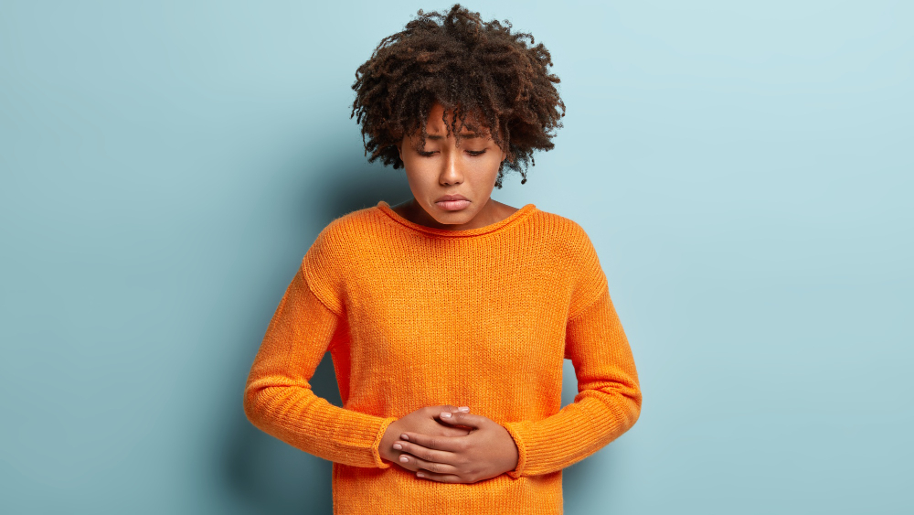 woman holding her stomach in pain