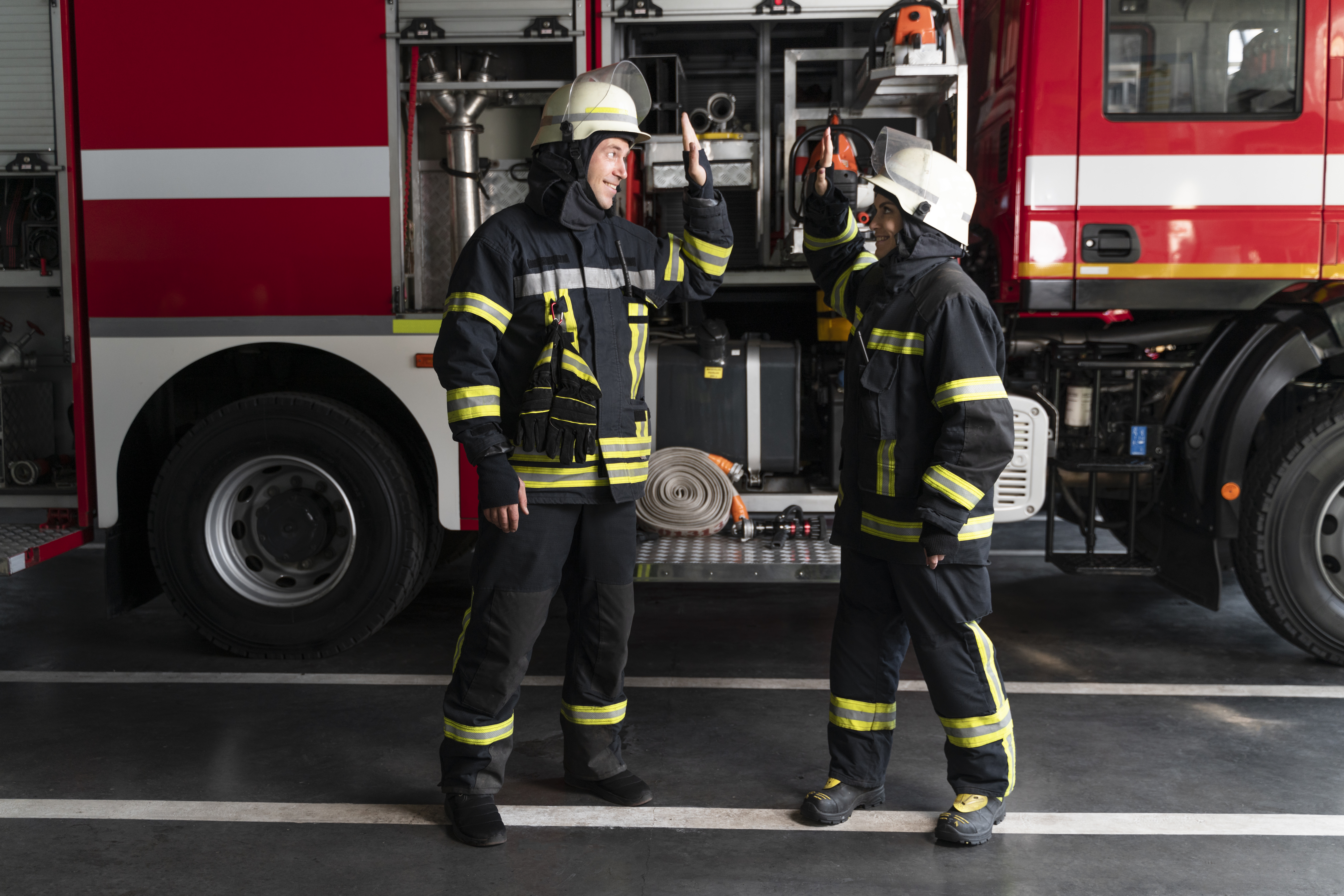 male-female-firefighters-station-high-fiving-after-success-mission